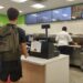 A Lipscomb student waiting in line at Freshens, with a warning sign about student IDs sitting in front of him