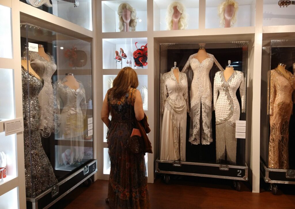 Dolly Parton's dress from her performance of "He's Alive" at the 1989 CMA Awards on display (pictured as the first white dress displayed on the right side)