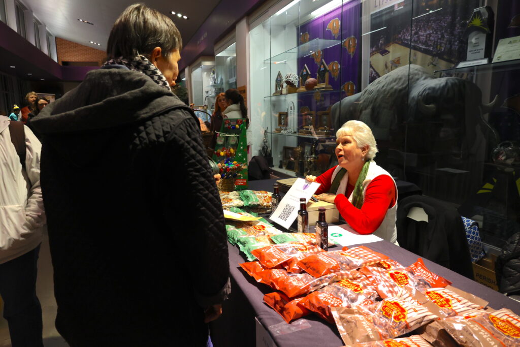 A customer looks on at a vendor's table at the "Merry Marketplace" at the 19th annual Lighting of the Green.
