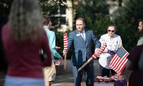 San Lynn, director of veteran services, handing out American flags during the 9/11 observance.