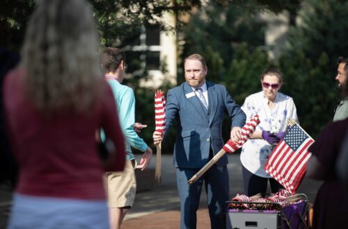 San Lynn, director of veteran services, handing out American flags during the 9/11 observance.