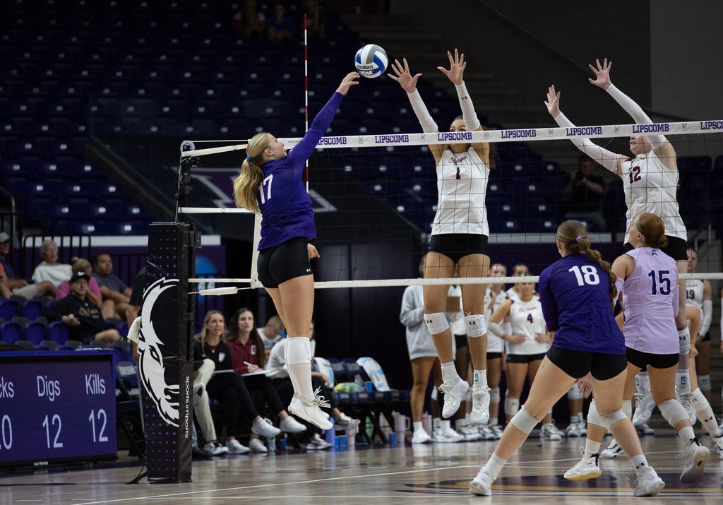 Fr. Madyson McCarthy spikes ball past defenders.